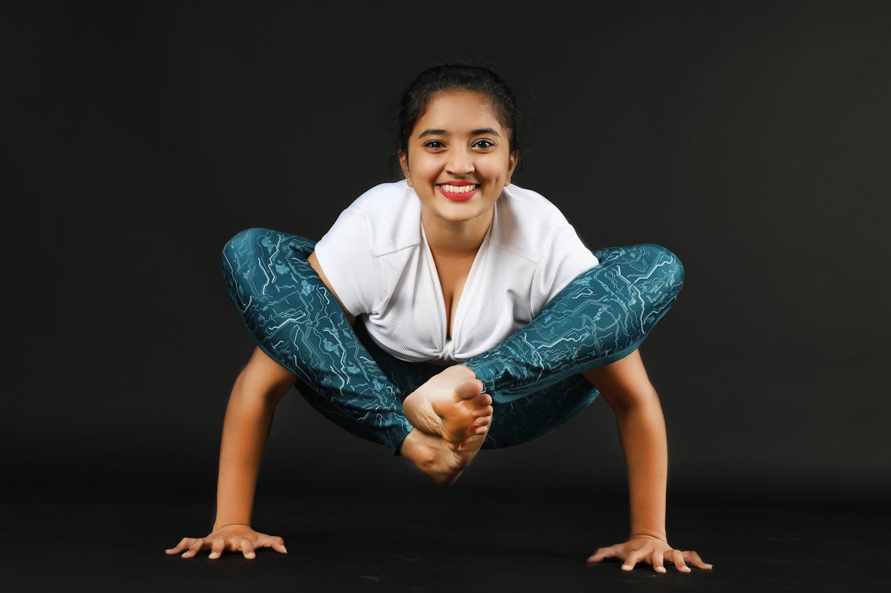 A young woman confidently performs an advanced yoga pose, showcasing flexibility and strength.